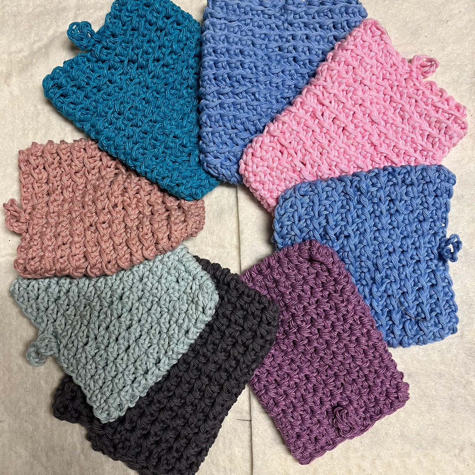 Set of crochet soap pouches in various colors.
