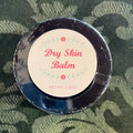 Dry Skin Balm container with label on a camouflage background