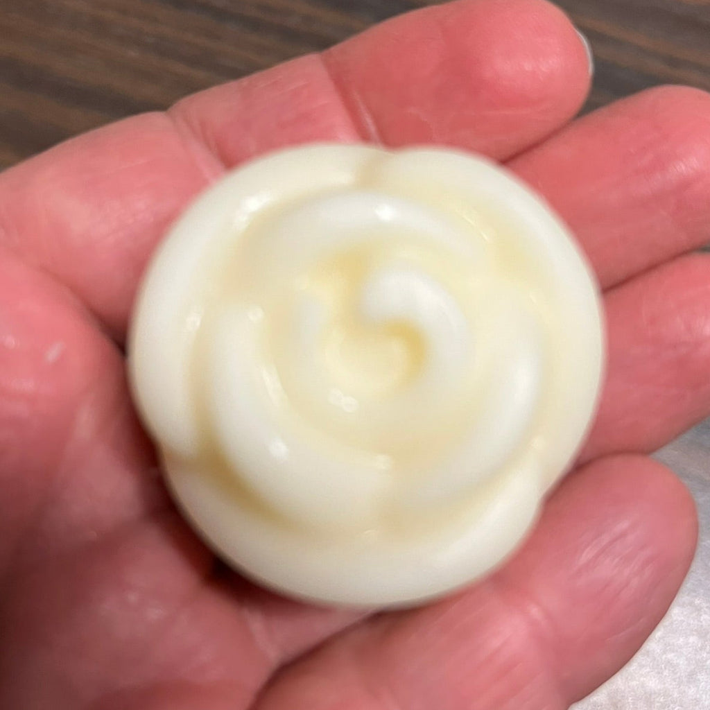 Solid lotion bar in hand