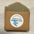 Handmade soap bar with a brown packaging label on a textured gray background