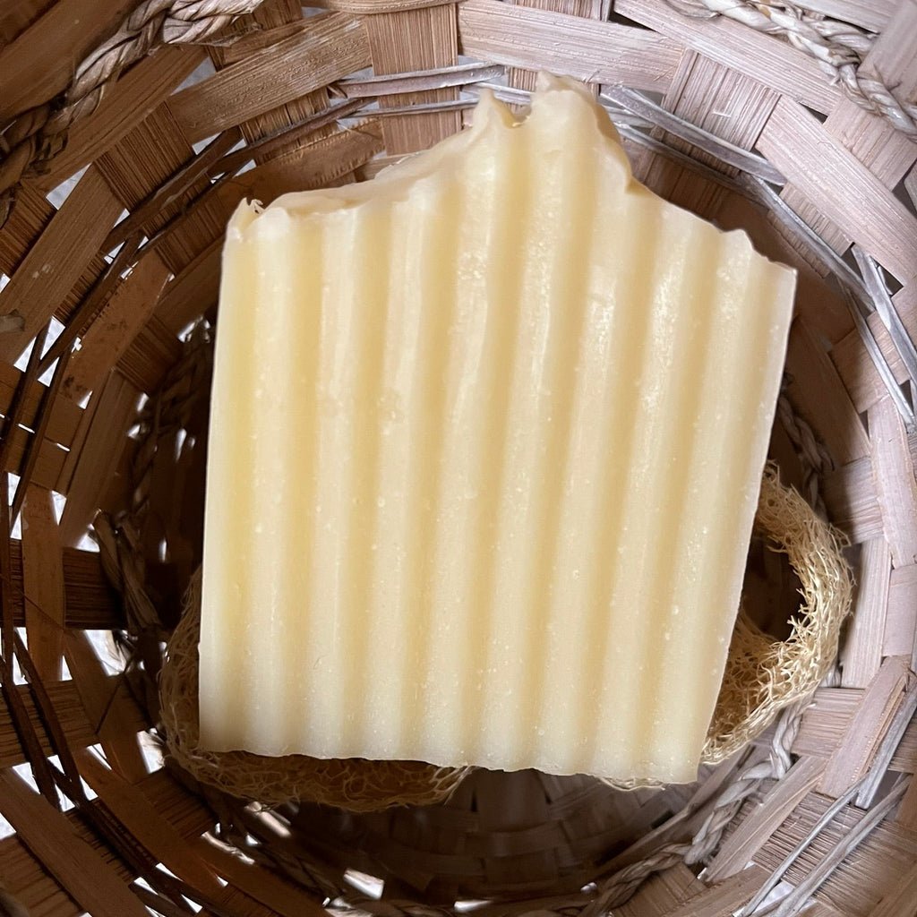 Bar of soap on a wooden surface with a woven basket